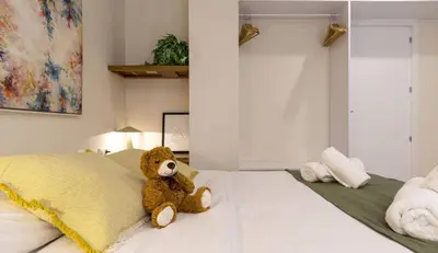 a teddy bear sitting on top of a bed at Osito Hub - l'Explorador Andrés in Valencia