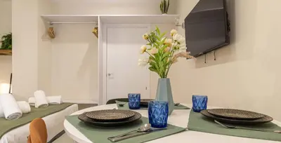 a table with plates and a vase with flowers on it at Osito Hub - l'Explorador Andrés in Valencia