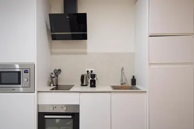 a white kitchen with a microwave and a sink at Osito Hub - l'Explorador Andrés in Valencia