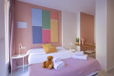 a teddy bear sitting on a bed in a room at Osito Hub - l'Explorador Andrés in Valencia