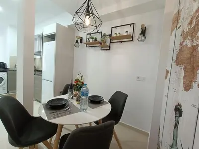 a dining room table with black chairs and a kitchen at MalvaLindaBeach Loft Benlliure Malvarrosa/Patacona in Valencia