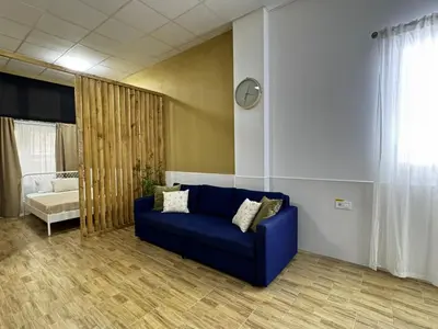 a living room with a blue couch and a window at Cooperativa 8 in Valencia