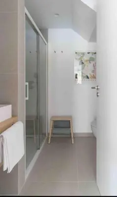 a bathroom with a shower and a wooden stool at Calma Villa. Chalet de lujo, jacuzzi y piscina in Valencia