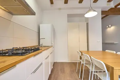 a kitchen with white cabinets and a wooden counter top at Apartamento minimalista en Matemático Marzal in Valencia