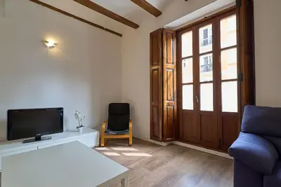 a living room with a tv and a blue couch at Apartamento minimalista en Matemático Marzal in Valencia
