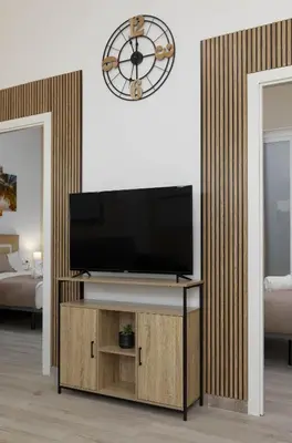 a living room with a television and a clock on the wall at Malvarrosa Las Arenas Access in Valencia