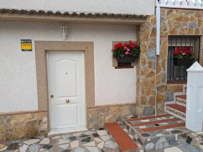 a building with a white door and two flower boxes at Chalet con piscina, barbacoa y jacuzzi en Valencia in Turís