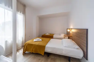 a bedroom with two beds and a large window at Furio Silence in Valencia