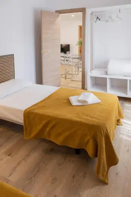 a bedroom with a bed with a yellow blanket on it at Furio Silence in Valencia