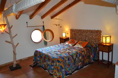a bedroom with a bed and a mirror on the wall at La Casa Del Teix in Eslida