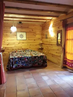 a bedroom with a bed in a wooden room at La Casa Del Teix in Eslida