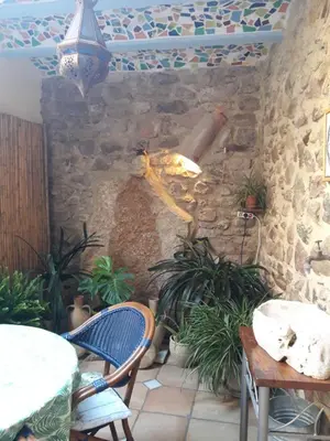 a patio with a stone wall and a table and chairs at La Casa Del Teix in Eslida