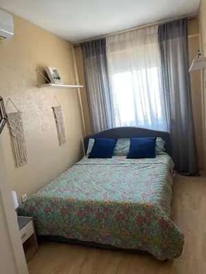 a bedroom with a bed with blue pillows and a window at Cullera Mountain View in Cullera