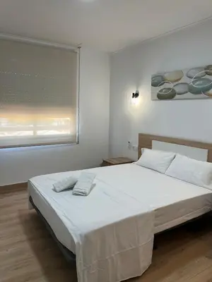 a bedroom with a large white bed with a window at Key Reig in Almussafes