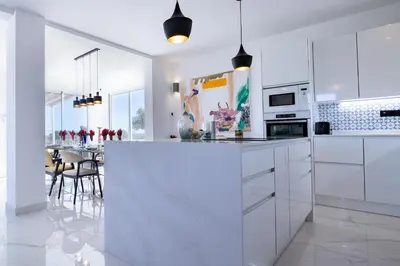 a kitchen with white cabinets and a table with chairs at La Villa de Luz in Torrent