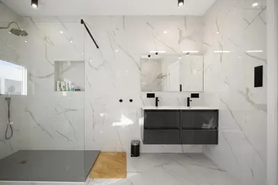 a white bathroom with a sink and a shower at La Villa de Luz in Torrent