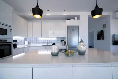 a white kitchen with a bowl of fruit on a counter at La Villa de Luz in Torrent