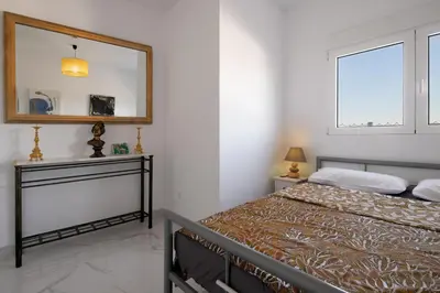 a bedroom with a bed and a mirror on the wall at La Villa de Luz in Torrent
