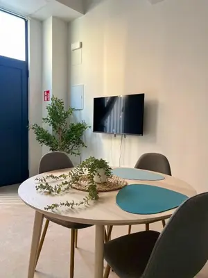 a room with a table with chairs and a tv at Non Stress Templo in Valencia
