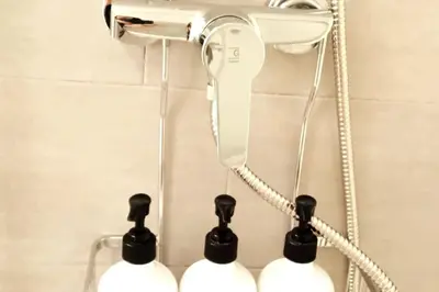 a blow dryer hanging on a wall with three bottles at Apartamento frente al mar in Cullera