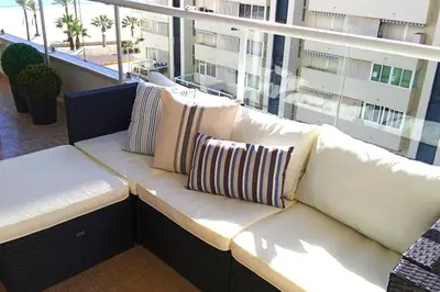a white couch sitting on top of a balcony at Apartamento frente al mar in Cullera