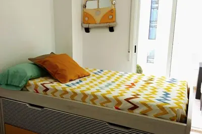 a bed with a colorful comforter in a bedroom at Apartamento frente al mar in Cullera