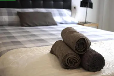 a pile of brown rolled towels on a bed at Tus Habitaciones en Ruzafa in Valencia