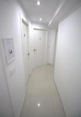 an empty hallway with white walls and white floors at Tus Habitaciones en Ruzafa in Valencia