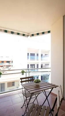 a table and chairs on a balcony with a large window at Tú & Yo Moncofa in Moncófar