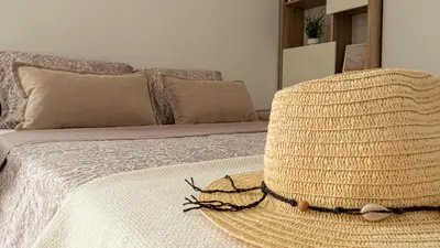 a straw hat sitting on top of a bed at Tú & Yo Moncofa in Moncófar