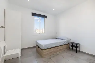 a white bedroom with a bed and a window at Placid Puerto in Puerto de Sagunto
