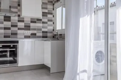 a kitchen with a sink and a washing machine at Placid Puerto in Puerto de Sagunto
