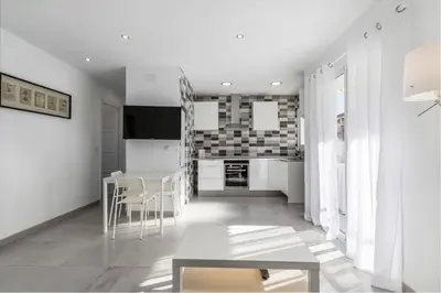 a living room with a table and a kitchen at Placid Puerto in Puerto de Sagunto