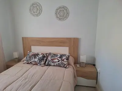 a bedroom with a bed with two lamps and two pillows at Cullera Playa in Cullera