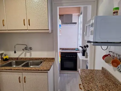 a small kitchen with a sink and a microwave at Cullera Playa in Cullera