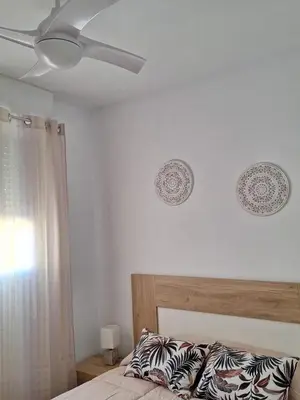 a bedroom with a bed and a ceiling fan at Cullera Playa in Cullera