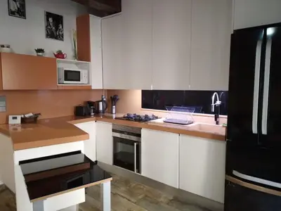 a kitchen with white cabinets and a black refrigerator at Valencia Centro Suite in Valencia