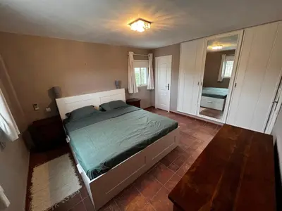 a small bedroom with a bed and a mirror at Casa el Girasol, rustig gelegen kindvriendelijke villa 10 p in Montroy