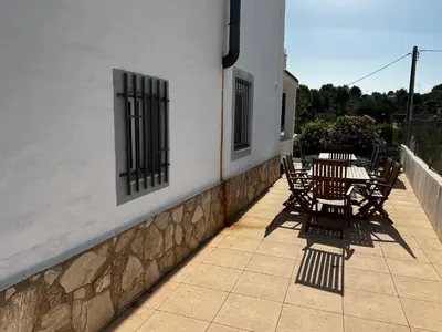 a patio with tables and chairs on the side of a building at Casa el Girasol, rustig gelegen kindvriendelijke villa 10 p in Montroy