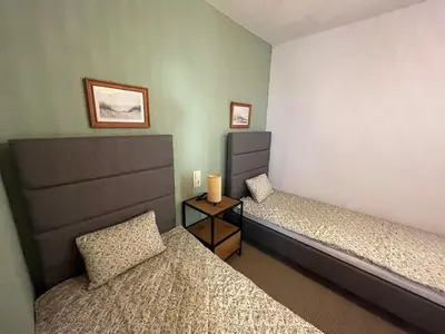 a room with two beds and a nightstand between them at Cap Blanc Apartment with Sea View and Beach in Cullera