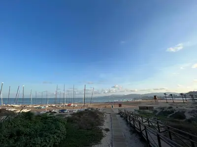 a beach with sailboats in the sand and a path at Cap Blanc Apartment with Sea View and Beach in Cullera