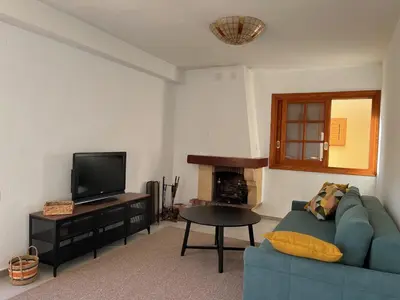 a living room with a blue couch and a television at Cap Blanc Apartment with Sea View and Beach in Cullera
