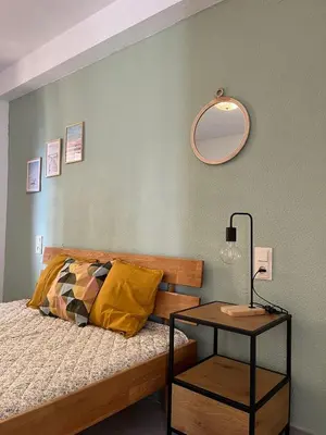 a bedroom with a bed with a table and a mirror at Cap Blanc Apartment with Sea View and Beach in Cullera