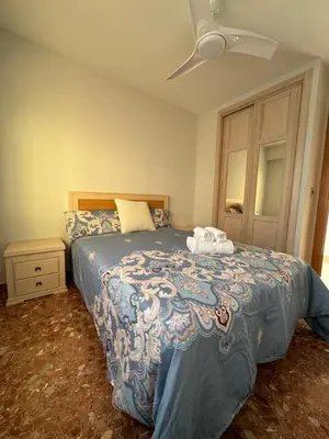 a bedroom with a bed and a ceiling fan at Apto. Cullera vistas espectaculares primera línea in Cullera