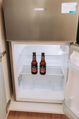 two bottles of beer sitting inside of an open refrigerator at Acogedor loft en Cabañal playa Malvarosa in Valencia
