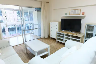 a living room with white furniture and a flat screen tv at Apartamento pobla farnals playa precioso in Las Canteras