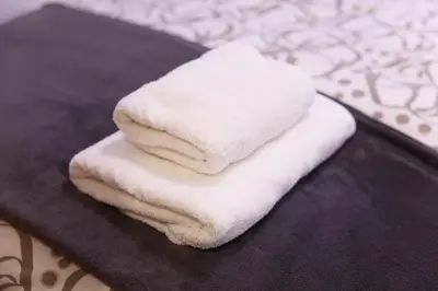 a stack of white towels sitting on a black towel at Apartamento pobla farnals playa precioso in Las Canteras