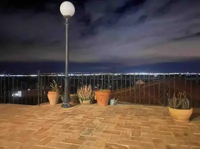a street light with potted plants on a balcony at night at Agradable Casa con maravillosas vistas in Chiva