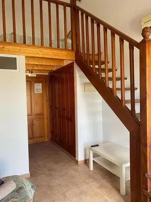 a wooden staircase with a bench in a room at Hostal Espai Mediterrani in Puebla de Vallbona