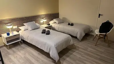 a hotel room with two beds and a chair at Loft para 6 pax, 15 min de Ciencias y Artes y AC in Valencia